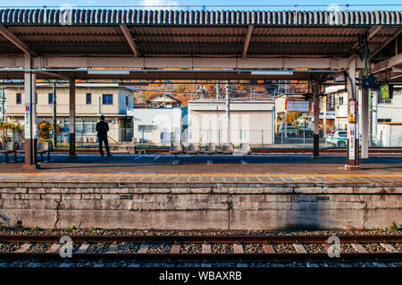 NOV 30, 2018 Otsuki, Japan - Japanische Passagier an ruhigen Otsuki Bahnsteig im warmen Sonnenlicht. Interchange Station zwischen JR und Fujikyu-Fuj Stockfoto