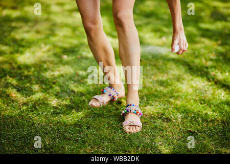 In der Nähe der Beine junge Frau mit Mückenschutz im Freien gesprüht wird, Stockfoto