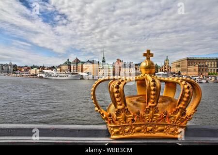 Stockholm, Schweden. Skeppsholmsbron (Skeppsholm Brücke) mit der berühmten Goldenen Krone und Altstadt im Hintergrund. HDR-Foto. Stockfoto