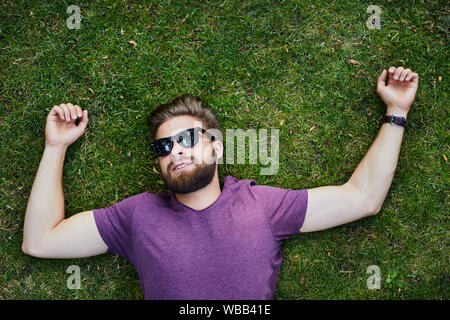 Motiviert junge Menschen, die auf dem Gras in einem Park und den Sommer genießen Stockfoto