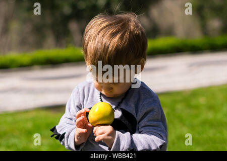 Kinder spielen mit Äpfeln im Frühjahr Stockfoto