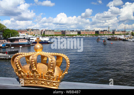 Stockholm, Schweden. Skeppsholmsbron (Skeppsholm Brücke) mit der berühmten Goldenen Krone und Strandvagen im Hintergrund. Stockfoto