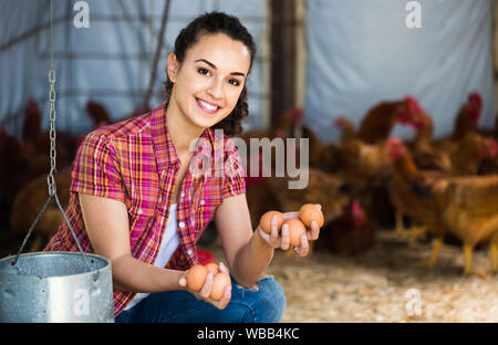 Porträt der jungen amerikanischen Frau Bauer Holding frische Eier in den Händen im Hühnerstall Stockfoto