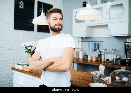 Zuversichtlich cafe Besitzer suchen mit Armen, während vor der Zähler überschritten Stockfoto