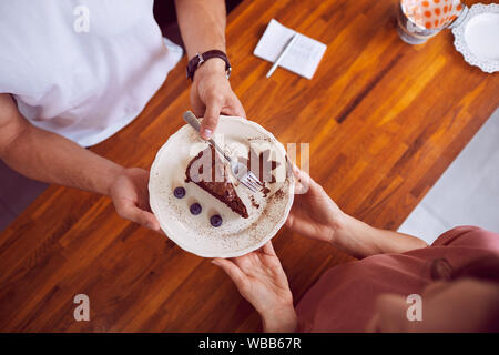 Blick von oben auf die Barkeeper, die weiblichen Kunden schön brownie Kuchen mit Holz- Zähler im Hintergrund vorbereitet Stockfoto