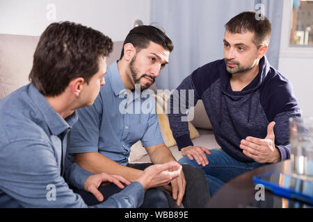 Zwei gestörte Männer, ernstes Gespräch mit ihrem Freund zu Hause Stockfoto