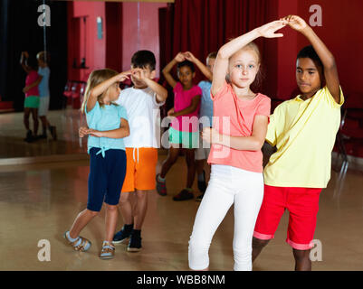 Lächelnd glücklich fröhliche Kinder Grundschule versuchen Salsa tanzen Tanz in modernen Studio Stockfoto
