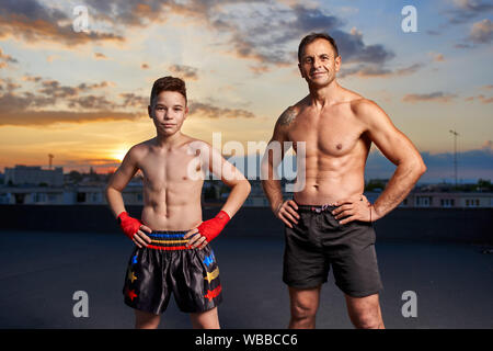 Junge Kämpfer und Trainer nach dem Training bei Sonnenuntergang posing Stockfoto