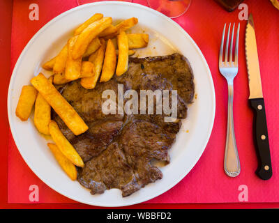 Lecker gebratenes Kalbsfilet mit Pommes Frites und Tomatensauce. Stockfoto