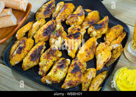 Gebackene Chicken Wings mit scharfer Sauce serviert auf Pfanne Stockfoto