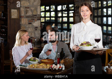 Positive Frau Kellner zeigen Land Restaurant Besucher Stockfoto