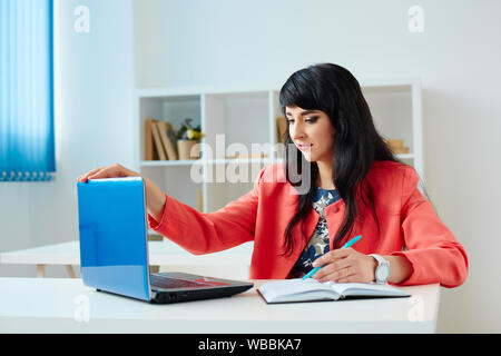 Attraktive Geschäftsfrau am Laptop im Büro oder Klassenzimmer arbeiten Stockfoto