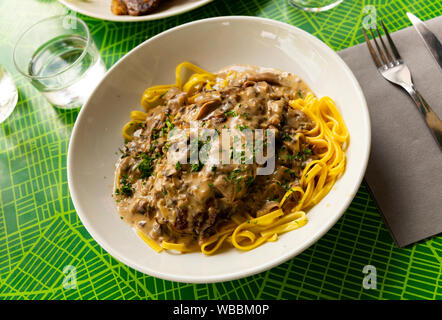 Traditionelle französische Gebratene Rippchen serviert mit Pilzsauce und Linguine Stockfoto