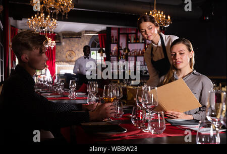 Freundlich lächelnd weibliche Kellner bringen um Besucher im luxuriösen Restaurant Stockfoto