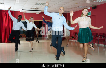 Paare von jungen Menschen üben twist Bewegungen im modernen Tanz Studio Stockfoto