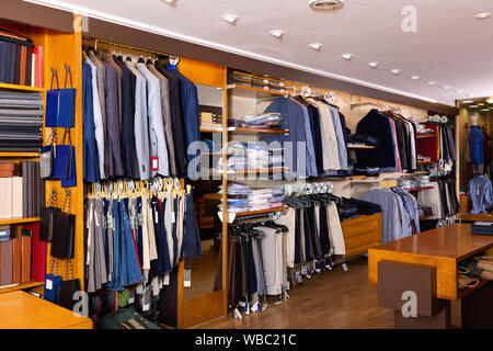 Mode moderne Schöne modische Männer Kleidung in den Regalen und Kleiderbügel Regale in Clothing Store angezeigt Stockfoto