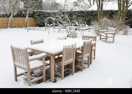 Terrasse Gartenmöbel bedeckt mit Schnee im Winter, Großbritannien Stockfoto