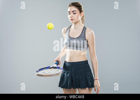 Eine Frau Tennisspieler Prellen des Balls auf dem Schläger, isoliert auf einem weißen Hintergrund. Stockfoto