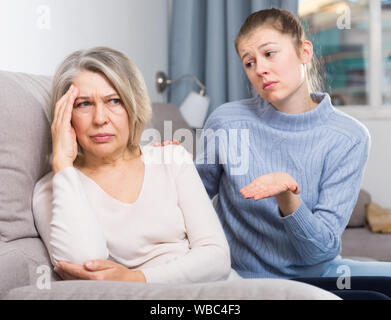 Portrait der beleidigten älteren Frau wandte sich von ihrer erwachsenen Tochter Stockfoto