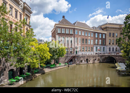 Utrecht, Niederlande - 01. JULI 2019: Stadtbild mit River Bridge in der Nähe von alten Gebäuden und leeren open Air Cafe am Bahndamm an einem sonnigen Tag Stockfoto