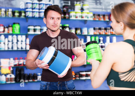 Junge körperlich fit Personen, die Sport Ernährung Produkte im Fachgeschäft Stockfoto