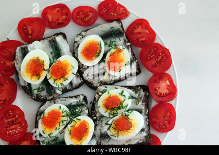 Roggenbrot Sandwich mit Fisch, Ei und Dill und Kaviar. Estnische traditionelle Köstlichkeit 'kiluvoileib' / 'kiluvõileib' Stockfoto