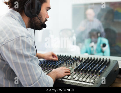 Fokussierte bärtigen Kerl in der Tontechnik engagiert, arbeiten bei Audio Control Panel im Radio Studio Stockfoto