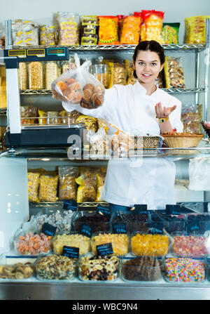 Happy bezaubernde Frau Verkauf von Cookies und anderen Füllungen Stockfoto