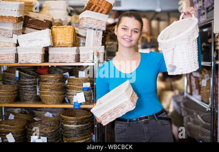 Junges Mädchen zeigt, Weidenkörbe in einem Dekor shop Stockfoto