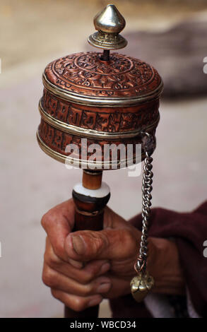 Buddhistischer Mönch mit Gebetsrad im Kloster Thiksey, Hand und Gebetsrad aus der Nähe, Ladakh, Indien Stockfoto