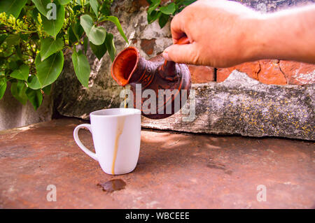 Ton Turk für Kaffee und eine weiße Schale auf die Wand im Hintergrund. Hintergrund. Stockfoto