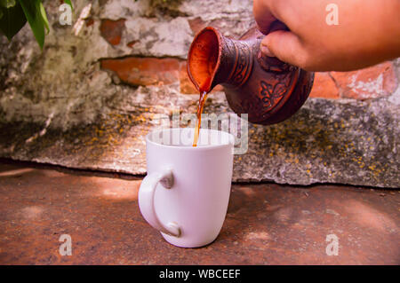 Ton Turk für Kaffee und eine weiße Schale auf die Wand im Hintergrund. Hintergrund. Stockfoto
