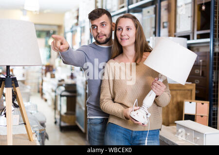 Junges Paar Auswahl Tischleuchte für Wohnung in Möbeln store Stockfoto