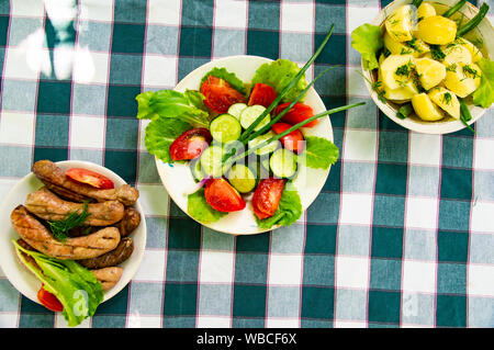 Gerichte auf den Tisch - Gemüse, Kartoffeln, Bayerische Würste. Hintergrund. Stockfoto