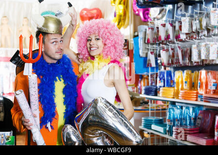 Freundliche Familie versucht, auf Helm mit Hörnern in festliche Accessoires Shop Stockfoto