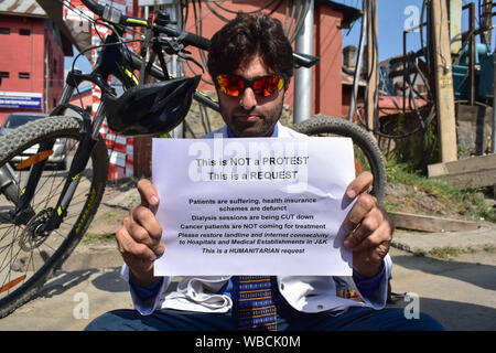 Kaschmir, Indien. 26 Aug, 2019. Srinagar, Indien. 26 Aug, 2019. Ein Arzt hält ein Plakat, während er gegen die Kommunikation blocade in Srinagar, Kashmir Proteste. Ein einsamer Arzt war protestieren gegen das krebsmittel Mangel aufgrund der Kommunikation Blockade, die von den Behörden der Aufhebung von Artikel-370 welche besonderen Status in Jammu und Kaschmir gibt Post eingeführt. Credit: SOPA Images Limited/Alamy Live News Credit: SOPA Images Limited/Alamy leben Nachrichten Stockfoto