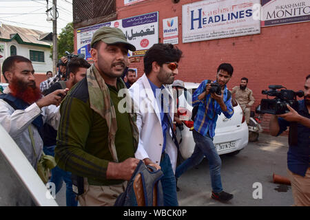 Kaschmir, Indien. 26 Aug, 2019. Srinagar, Indien. 26 Aug, 2019. Ein Polizist hält einen Doktor, der gegen die Kommunikation blocade in Srinagar, Kashmir protestiert wurde. Ein einsamer Arzt war protestieren gegen das krebsmittel Mangel aufgrund der Kommunikation Blockade, die von den Behörden der Aufhebung von Artikel-370 welche besonderen Status in Jammu und Kaschmir gibt Post eingeführt. Credit: SOPA Images Limited/Alamy Live News Credit: SOPA Images Limited/Alamy leben Nachrichten Stockfoto