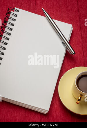 Leere Spirale Art Skizzenbuch mit einer Tasse Kaffee gegen strukturierte Krepppapier Stockfoto