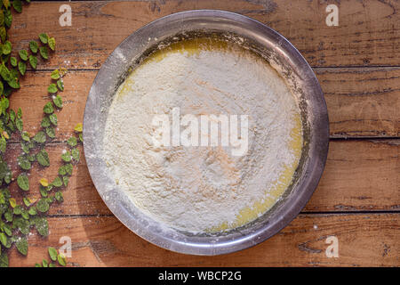 Schüssel mit Zutaten zu einem Glutenfrei Bananen Kuchen auf einer hölzernen Oberfläche mit grünen Blätter machen Stockfoto