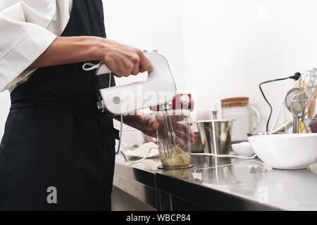 Foto, ein hübscher junger Koch Koch in der Küche kochen in Innenräumen abgeschnitten. Stockfoto