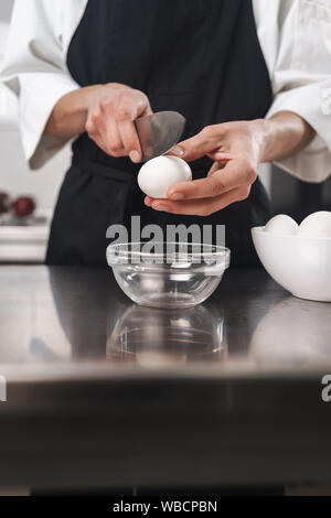 Foto, ein hübscher junger Koch Koch in der Küche kochen in Innenräumen abgeschnitten. Stockfoto