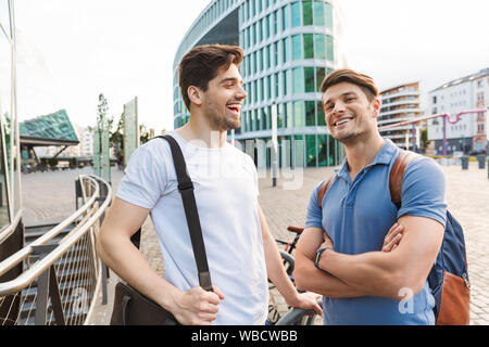 Zwei lächelnde junge Männer Freunde lässig gekleidet, Zeit in der Stadt, im Gespräch Stockfoto