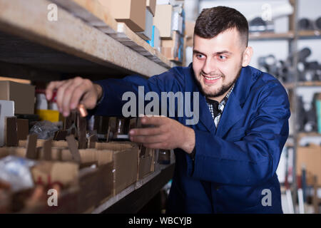 Erwachsene männliche Arbeitnehmer Sortierung Sanitärtechnik Details in der Werkstatt Stockfoto