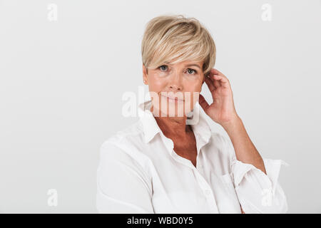 Portrait Nahaufnahme des eleganten erwachsenen Frau mit kurzen blonden Haaren an Kamera mit weißem Hintergrund im Studio isolierte suchen Stockfoto