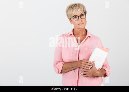 Portrait von erwachsenen Frau tragen Brillen holding Studium Buch über weissen Hintergrund im Studio isoliert Stockfoto