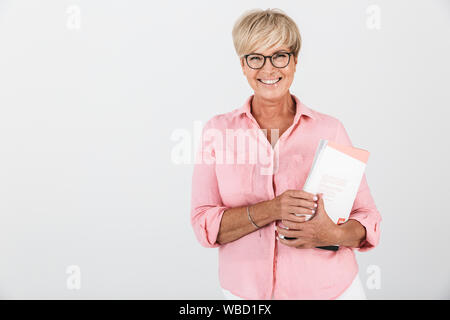 Portrait von glücklichen erwachsenen Frau tragen Brillen holding Studium Buch über weissen Hintergrund im Studio isoliert Stockfoto