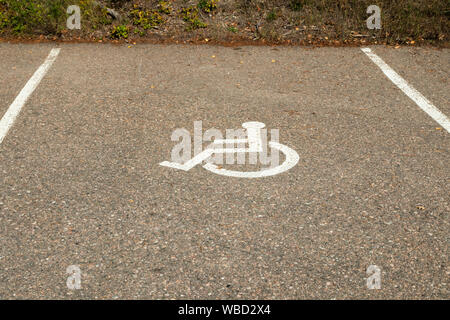 Deaktiviert das Symbol Zeichen auf Asphalt in der Parkplatz. Internationale Kennzeichnungen für einen behinderten Parkplatz. Stockfoto