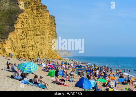 West Bay Dorset, Großbritannien. 26. August 2019. UK Wetter. Erholungssuchende und Sonnenhungrige in Scharen zu den Strand am Strand von West Bay in Dorset an einem Tag von glühend heiße Sonne auf Feiertag Montag. Foto: Graham Jagd-/Alamy leben Nachrichten Stockfoto