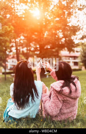 Zwei junge Frau feiern mit Toast im Park Stockfoto