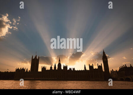 Dramatische Sonnenstrahlen hinter dem Palast von Westminster wie die Sonne in London setzt. Stockfoto